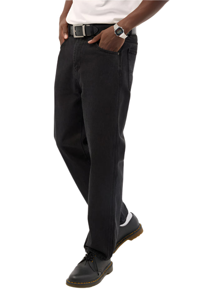 Person wearing black pants and black shoes on a white background