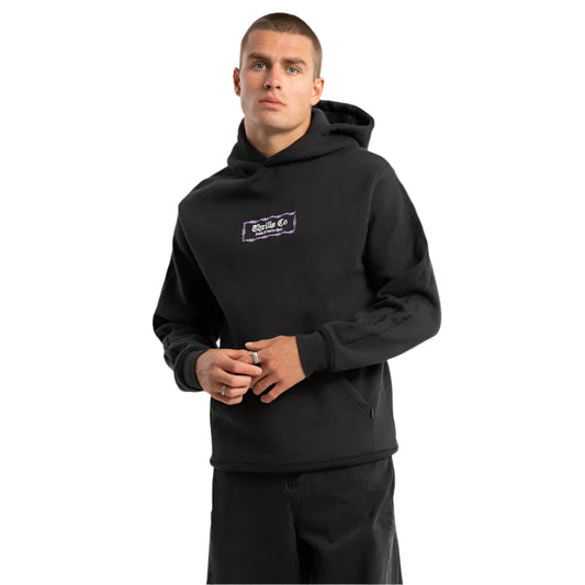 Person wearing a black hoodie with a logo on a light gray background