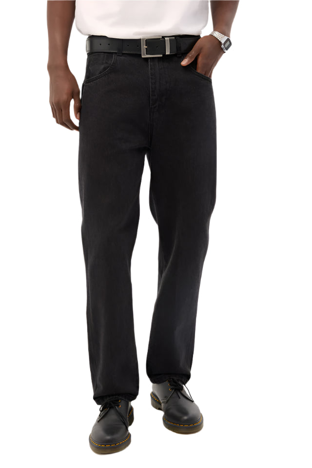 Person wearing black pants and a white shirt on a plain background