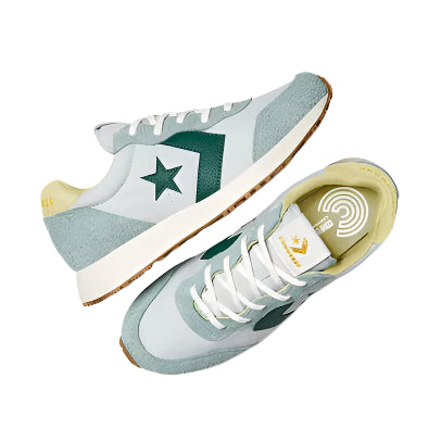 Pair of light blue sneakers with green accents on a white background