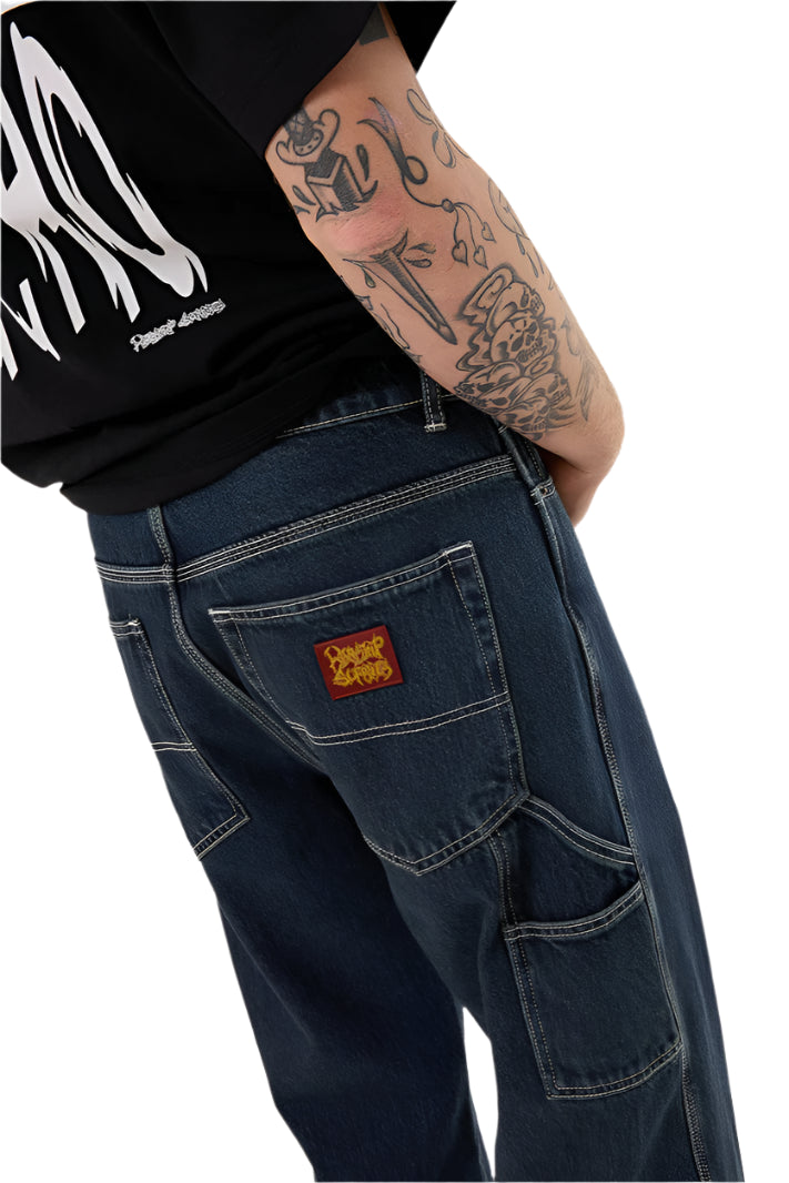Person wearing blue jeans with a brand logo on a white background