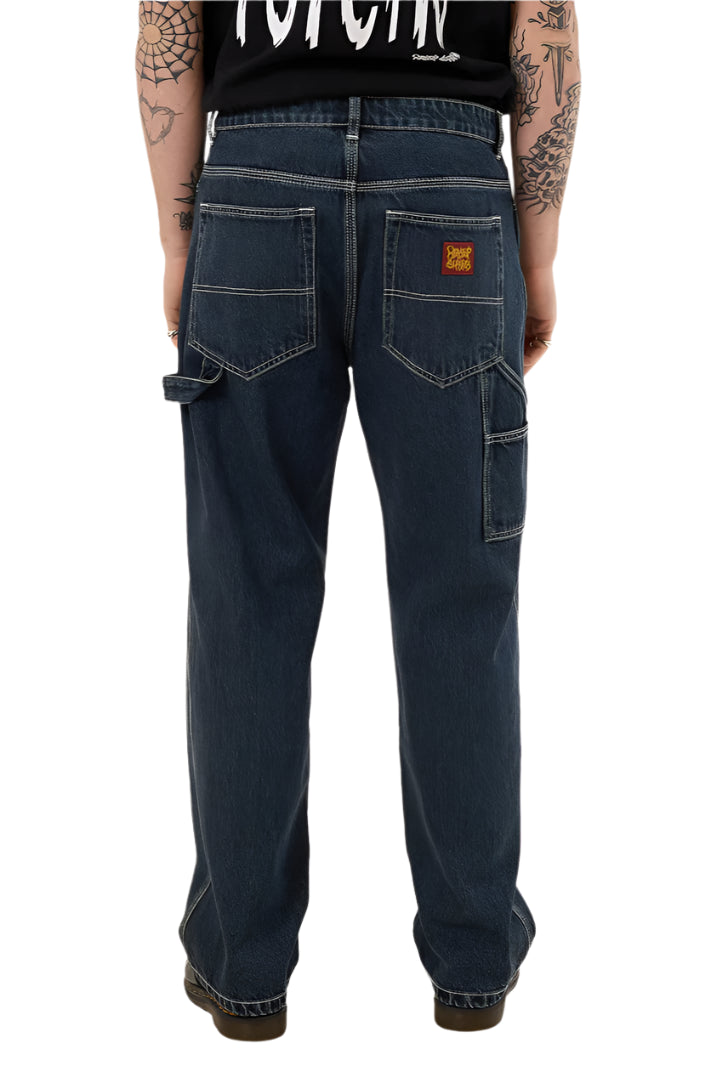 Person wearing dark blue jeans with a visible brand logo on a white background